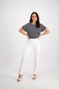 A woman stands with hands on hips, wearing a black and white striped top, slim leg stretch pants, and Vassalli Bay Pull On - White platform sandals, against a plain white background.