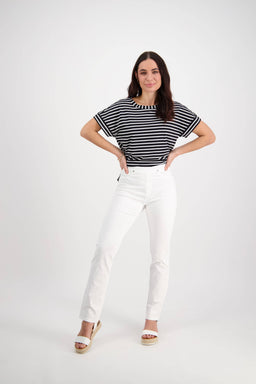A woman stands with hands on hips, wearing a black and white striped top, slim leg stretch pants, and Vassalli Bay Pull On - White platform sandals, against a plain white background.