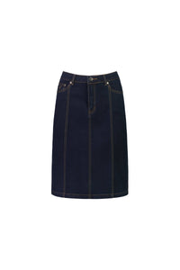The Vassalli Poppy Skirt in Indigo Denim is a dark blue stretch denim skirt with contrast stitching, front fly and button closure, belt loops, vertical seams, a straight above-the-knee cut, and classic five-pocket design.