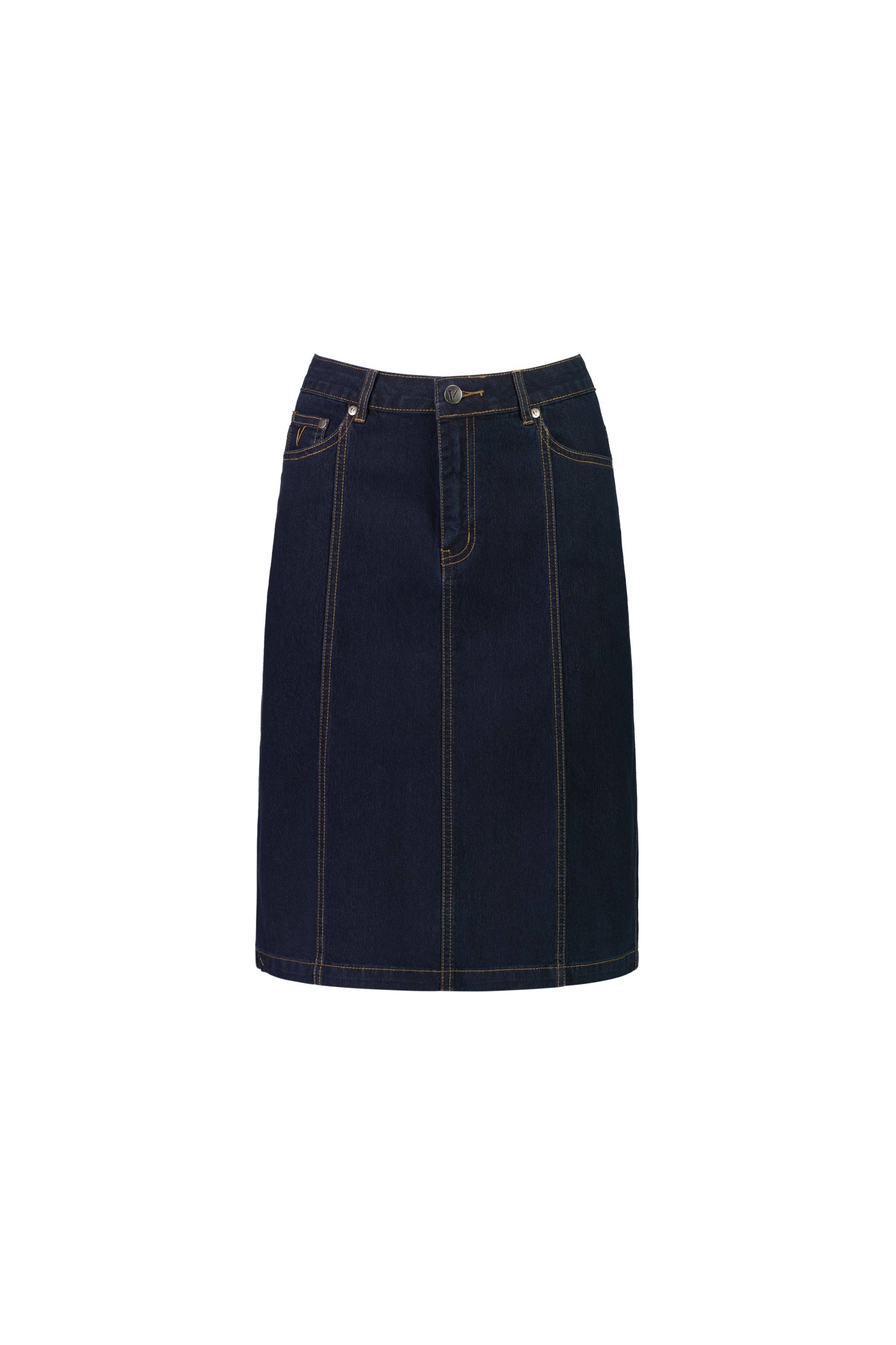 The Vassalli Poppy Skirt in Indigo Denim is a dark blue stretch denim skirt with contrast stitching, front fly and button closure, belt loops, vertical seams, a straight above-the-knee cut, and classic five-pocket design.