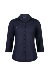 The Isla Shirt - Ink by Vassalli is a navy blue, slim fit, long sleeve button-up with a collared neckline, front chest pockets, tailored silhouette, and made from 100% cotton. Displayed on a white background.