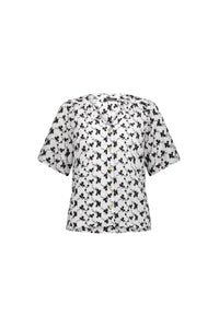 The Vassalli V-Neck Top - Floral features a black abstract floral print and short sleeves, with a button-up V-neck, shown on a plain white background.