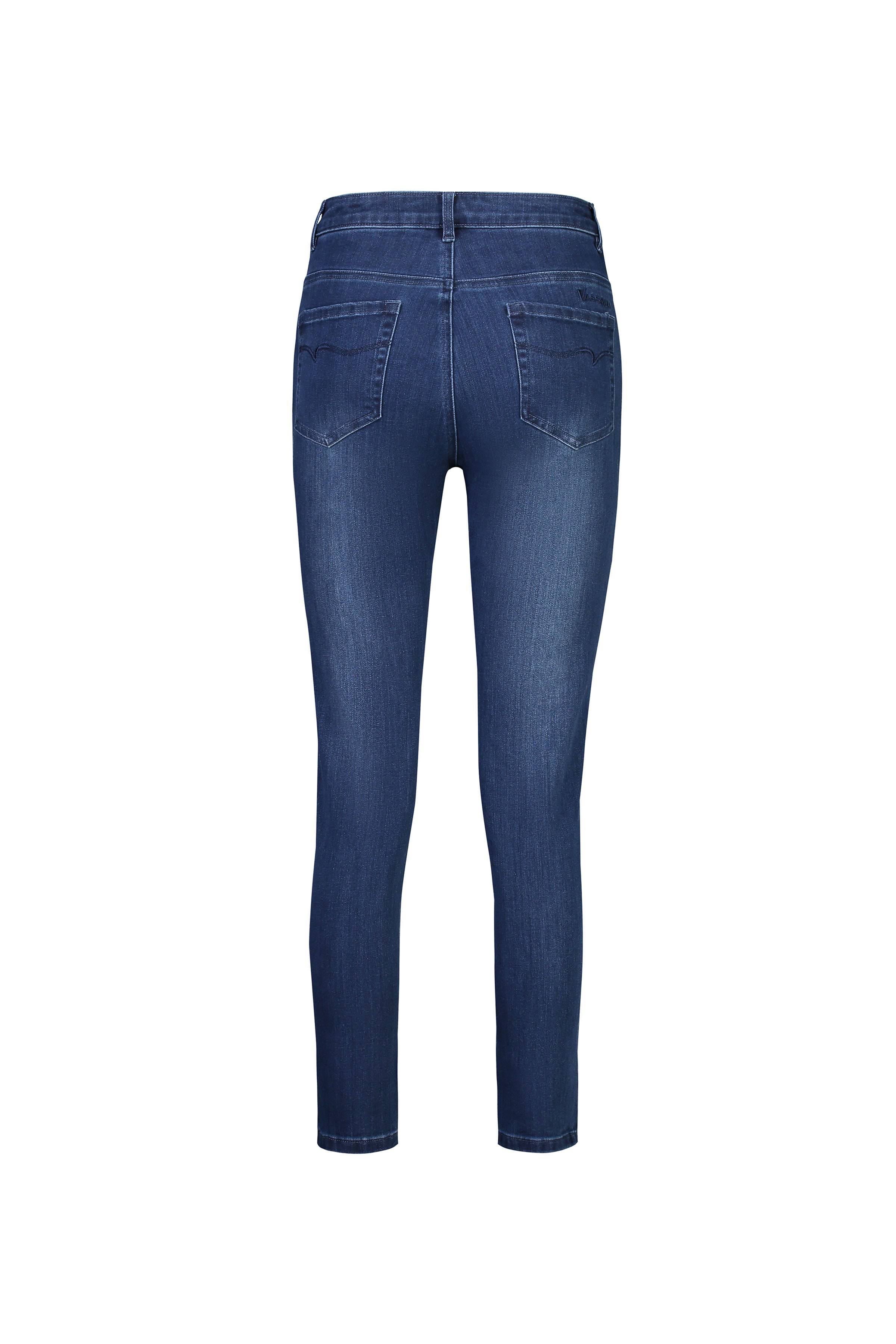 Back view of Vassalli Icon Jean in blue denim, showcasing a skinny leg ankle grazer fit with two back pockets and subtle fabric fading, displayed on a white background.