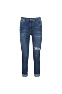The Vassalli Coast Jean in blue denim features a skinny leg, distressed details, rolled cuffs, front pockets, and a right thigh rip—an easy ankle grazer jean shown on a white background.
