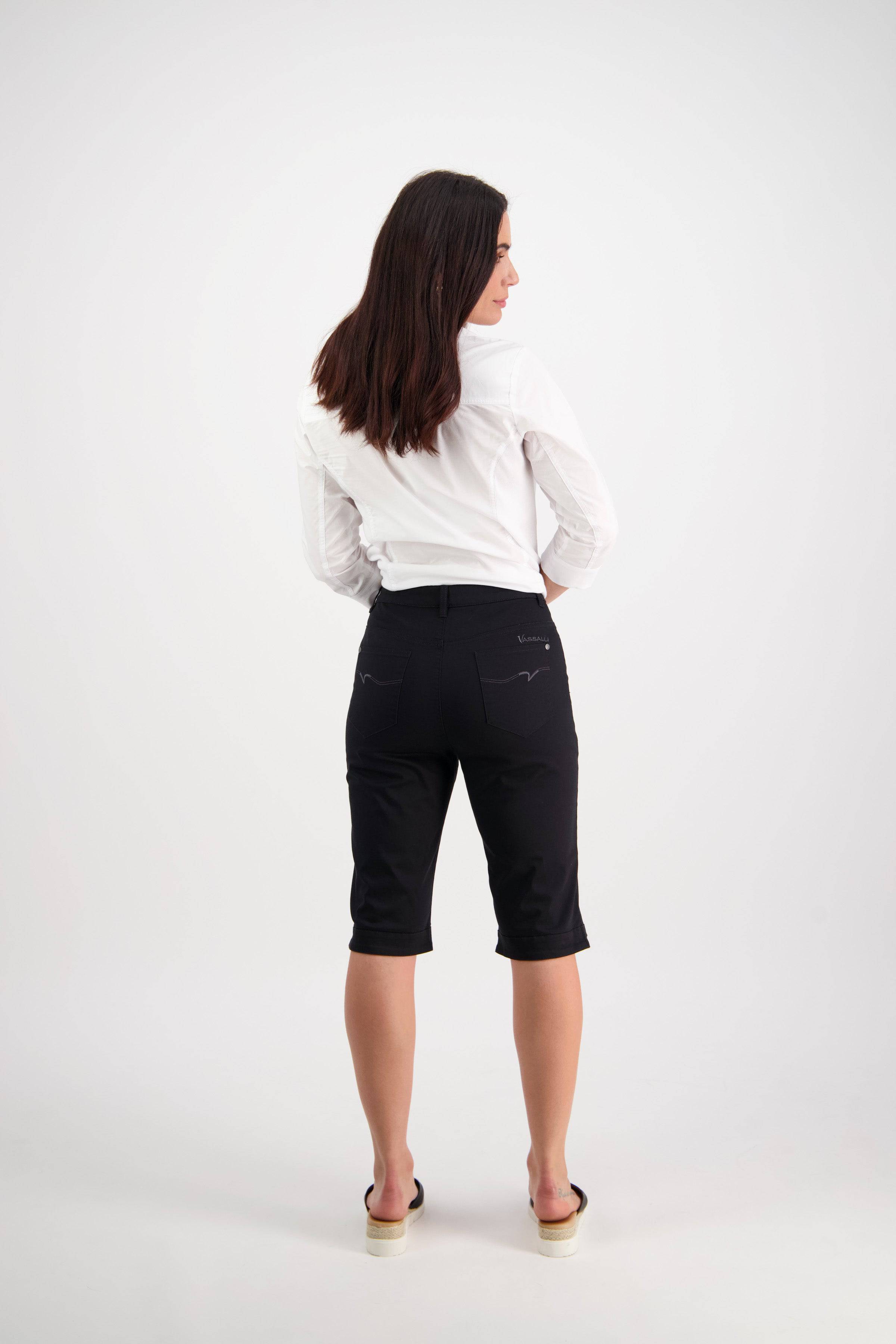 A woman with long brown hair, wearing a white shirt and Vassalli's Custom Lightweight Short in Black, stands facing away from the camera against a plain white background—ideal summer comfort and style.