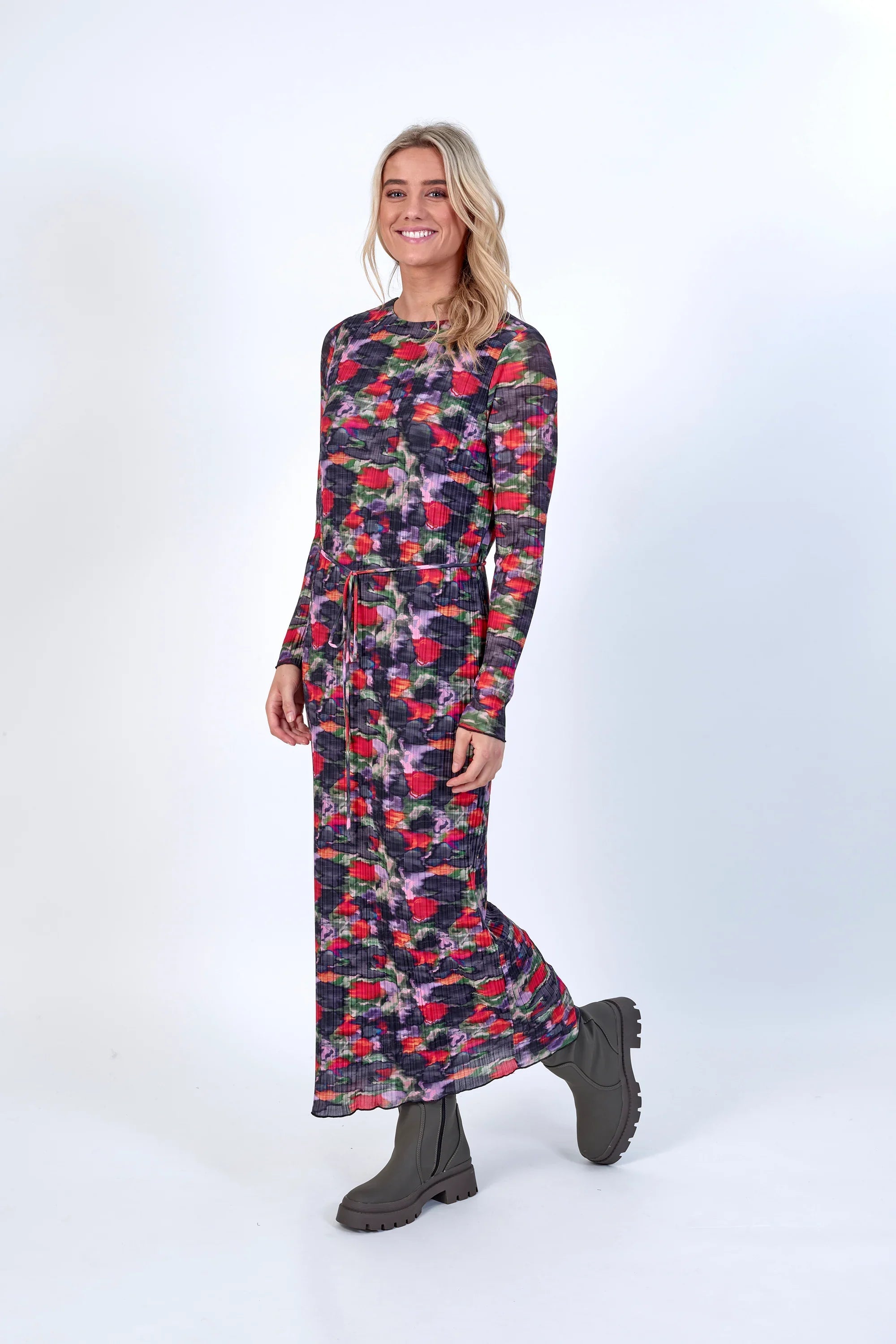 Woman wearing a long sleeve, floral print maxi dress with belt and chunky boots