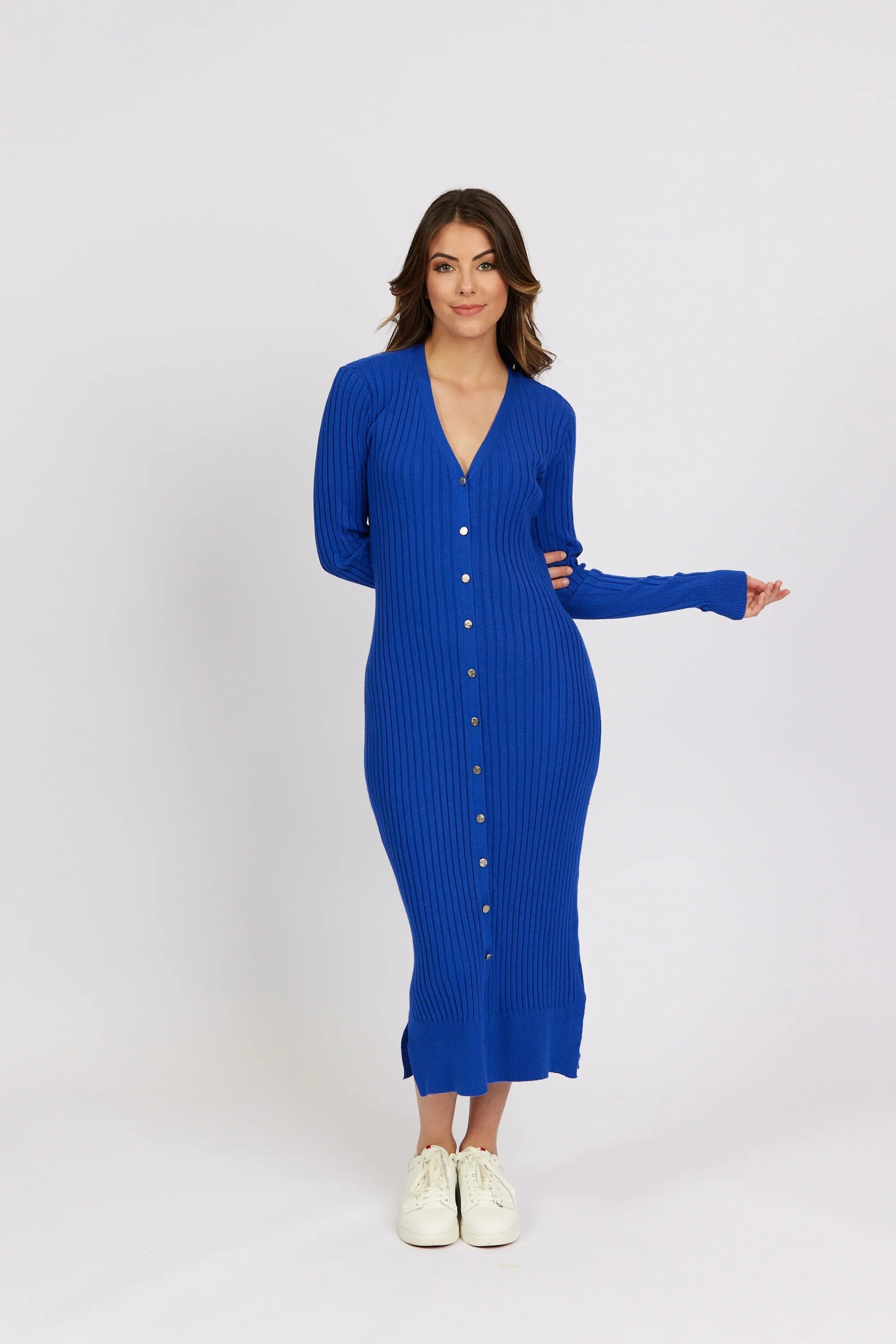 Woman wearing electric blue ribbed knit button-down long sleeve midi dress with white sneakers