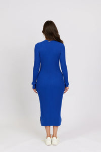 Woman wearing a ribbed electric blue knit midi dress with long sleeves, back view
