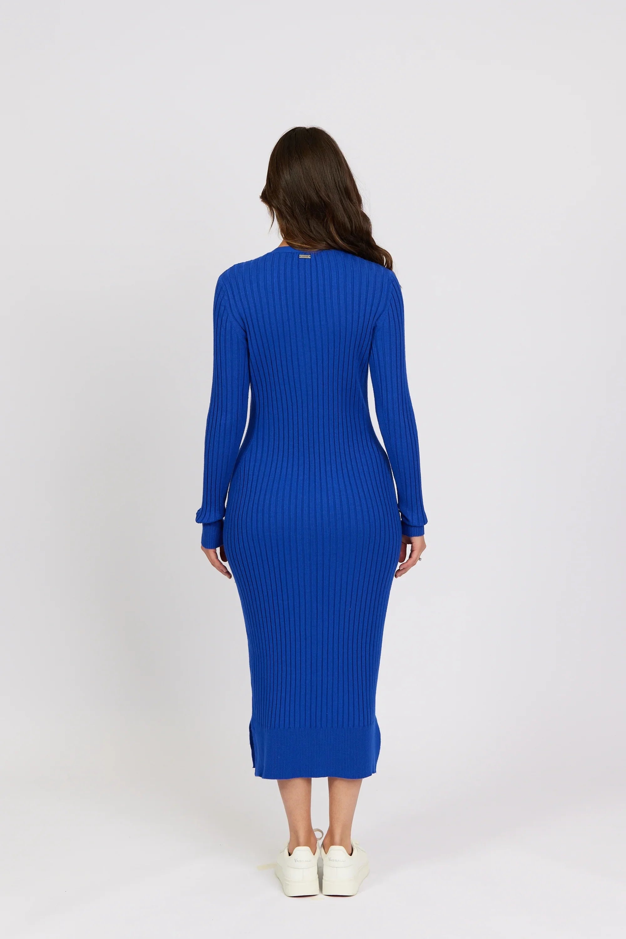 Woman wearing a ribbed electric blue knit midi dress with long sleeves, back view
