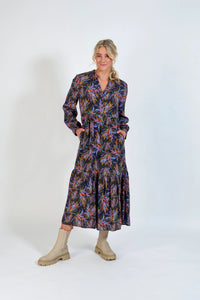 Woman wearing long-sleeve floral print midi dress with cream ankle boots, studio background