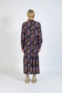 Back view of a woman wearing a long-sleeve floral midi dress with boots