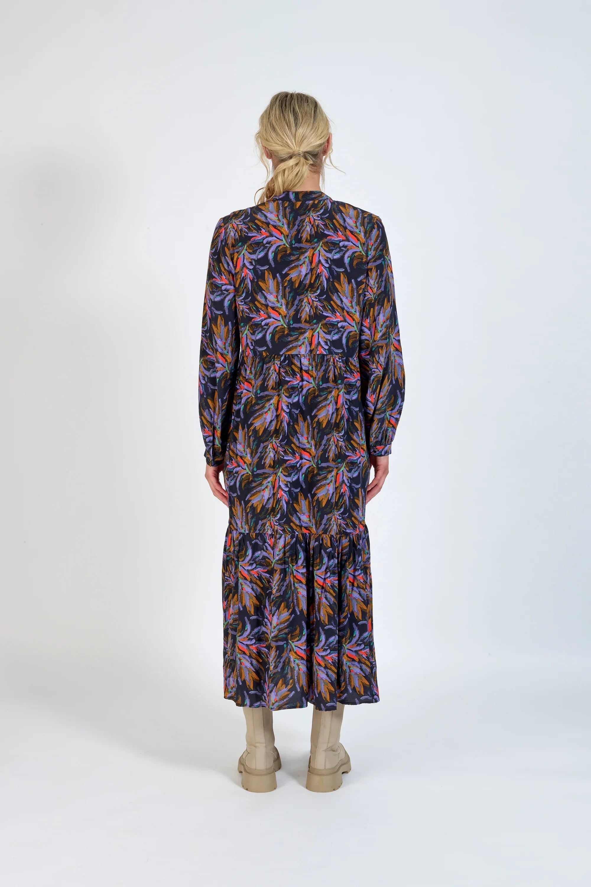 Back view of a woman wearing a long-sleeve floral midi dress with boots