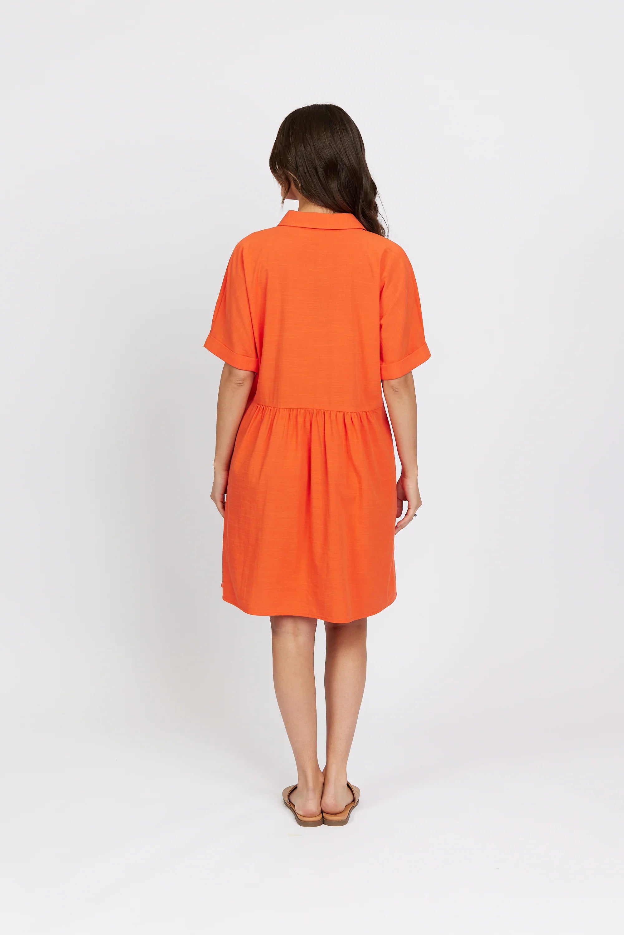 Back view of woman wearing short sleeve orange cocoon dress, casual style