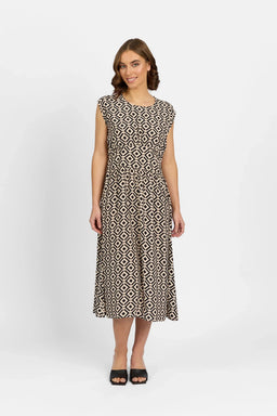 Woman wearing a black and beige geometric print midi dress, cap sleeves, black sandals