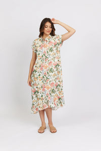 Woman wearing floral short-sleeve midi dress with ruffled hem, standing against white background