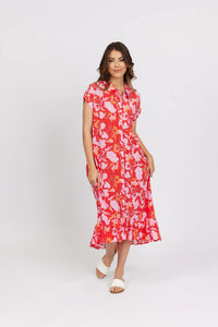 Woman wearing a vibrant floral button-down midi dress with short sleeves and ruffled hem
