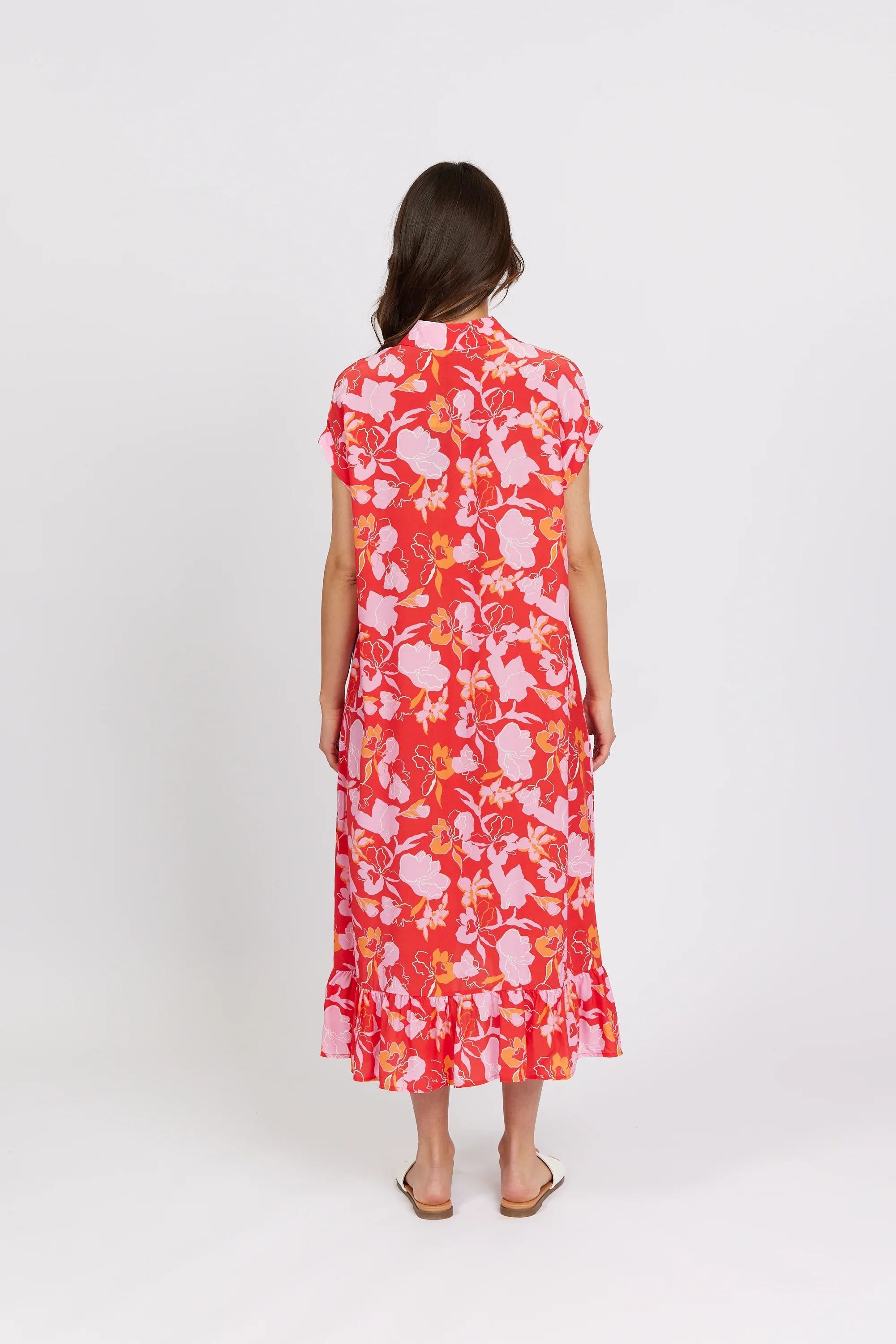 Back view of woman wearing a red floral midi dress with short sleeves and ruffle hem