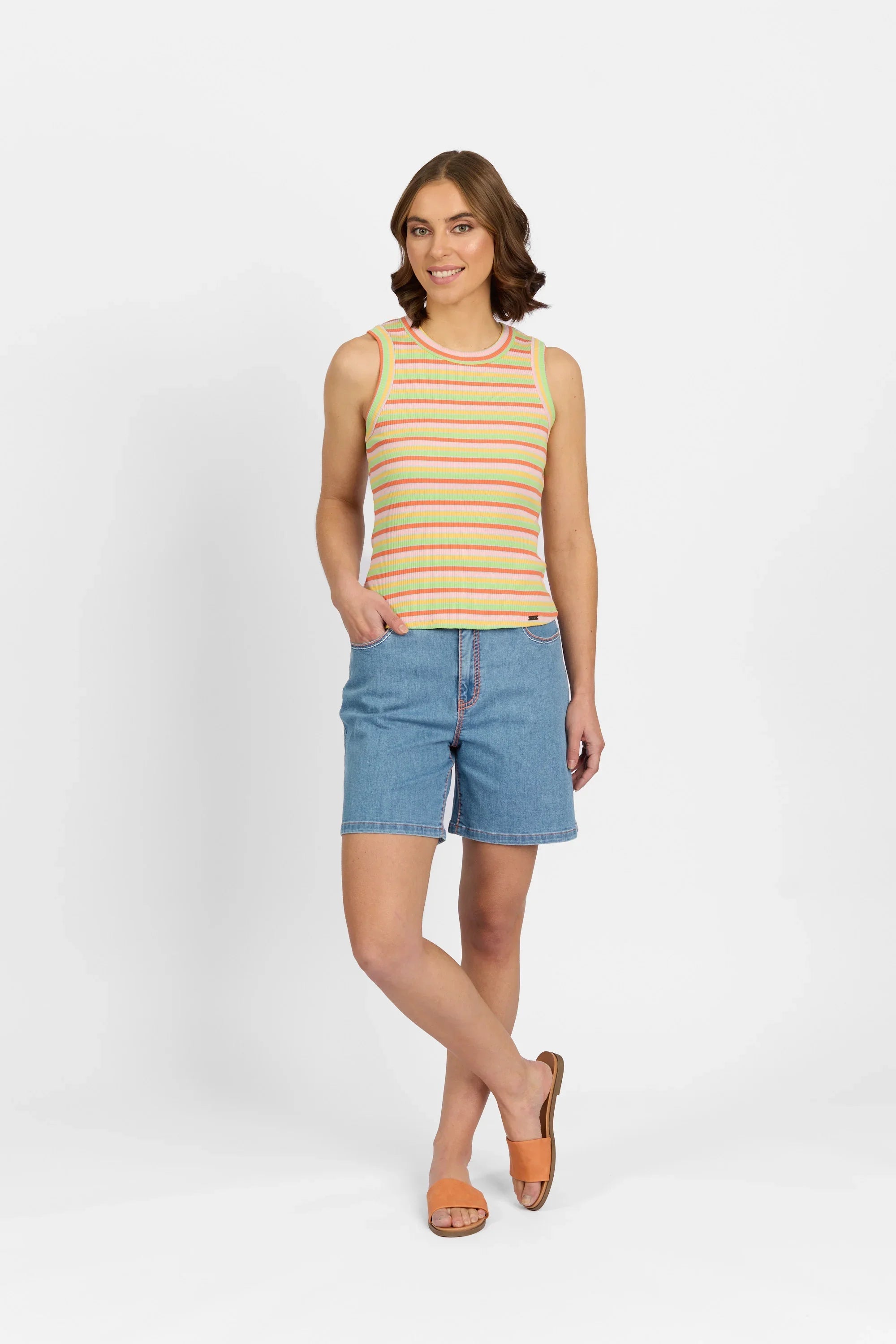 Woman wearing a sleeveless multicolour striped knit tank top with denim shorts and sandals