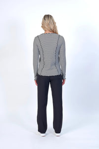 Back view of woman wearing black and white striped long sleeve top and black pants