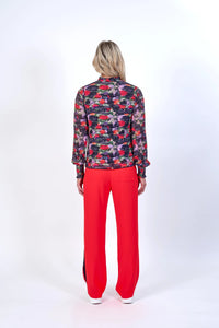 Back view of woman in long sleeve floral print top and bright red wide-leg pants