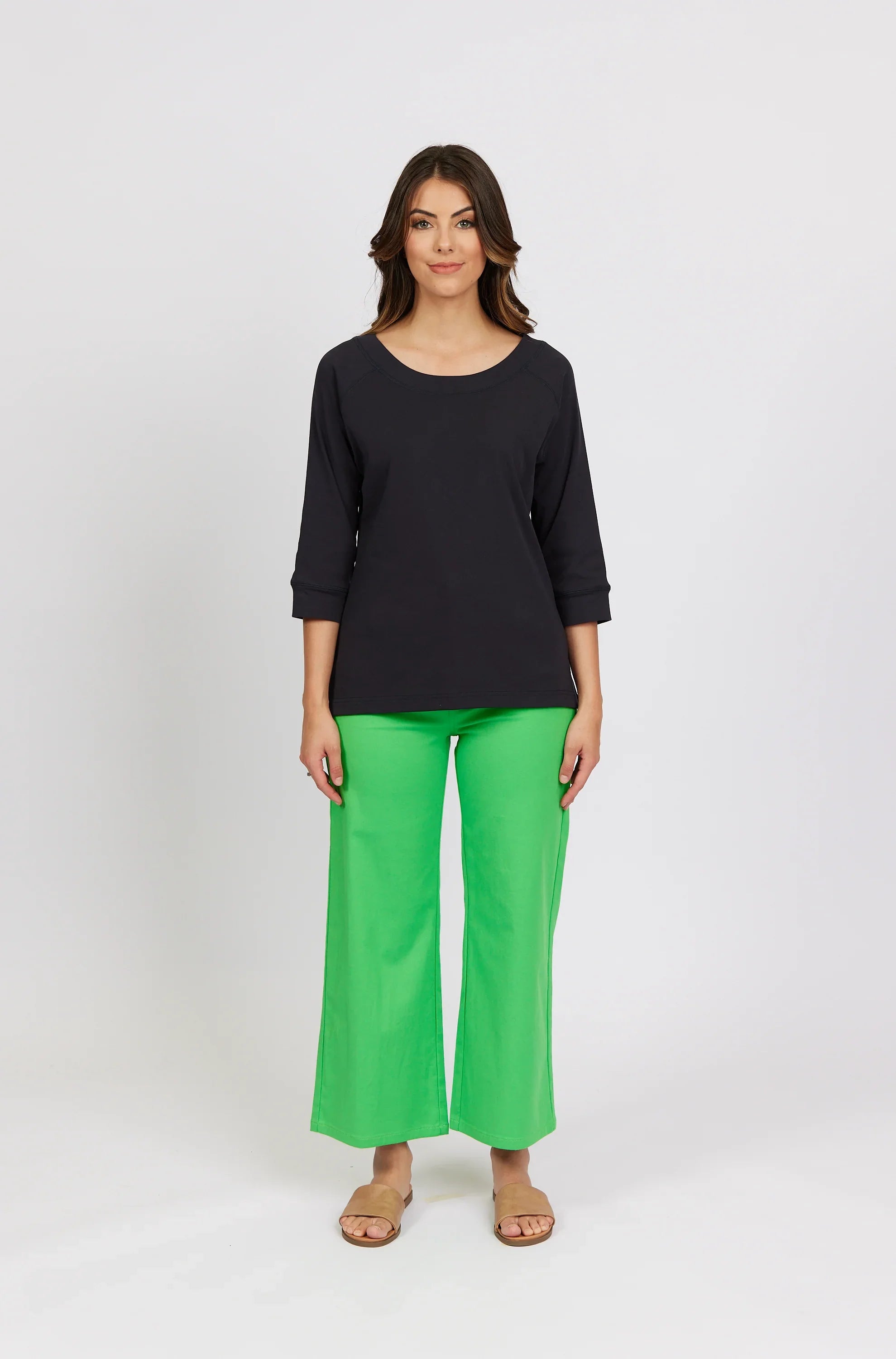 Woman wearing black three-quarter sleeve tee and bright green wide-leg pants