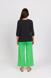 Back view of woman in black 3/4 sleeve top and bright green wide-leg pants