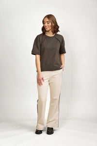 Woman wearing casual dark green short-sleeve tee and cream wide-leg pants