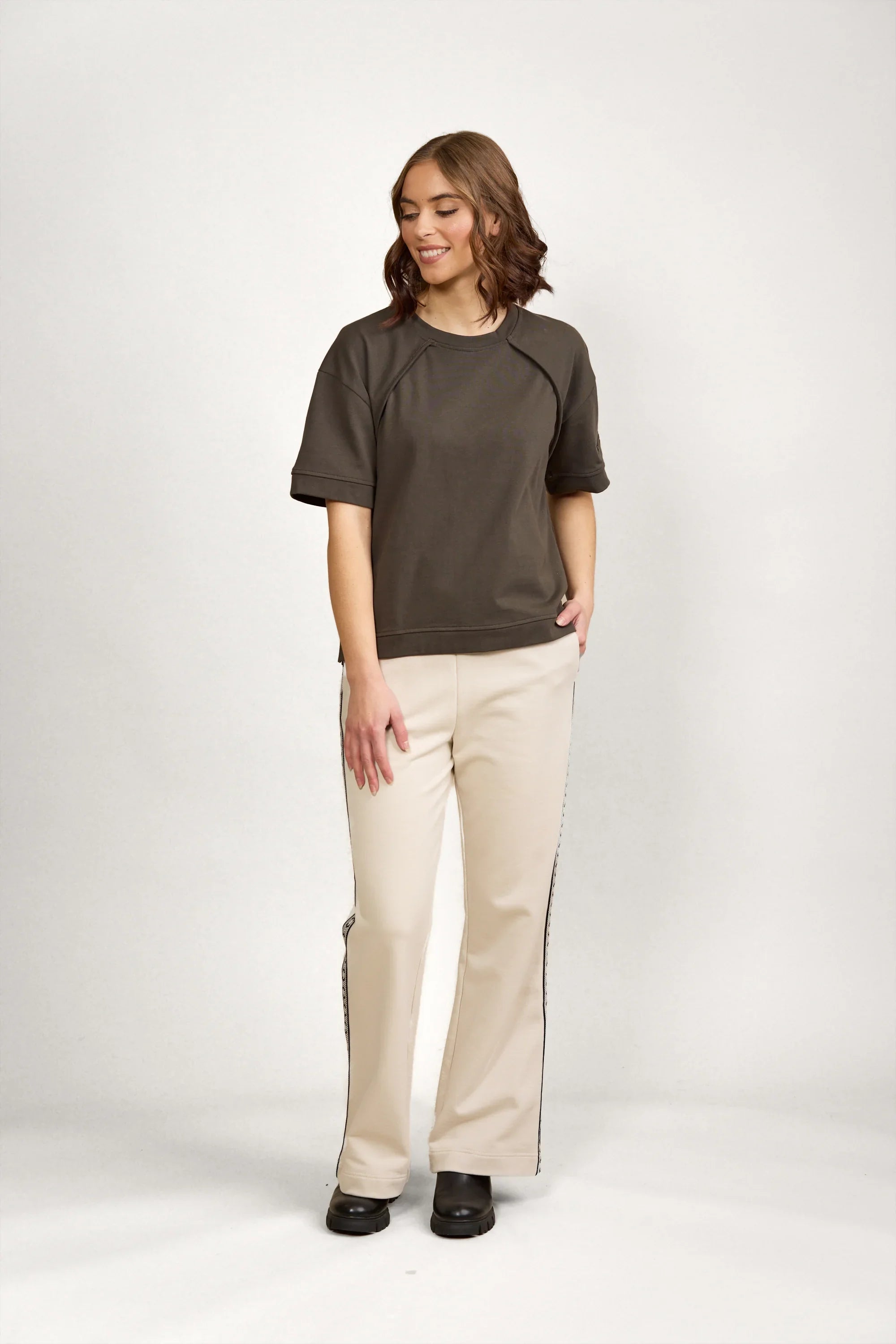 Woman wearing casual dark green short-sleeve tee and cream wide-leg pants