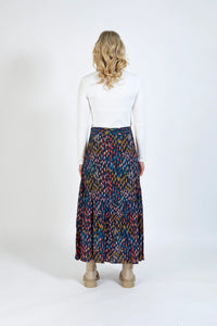 Back view of woman wearing colorful patterned maxi skirt and white ribbed top