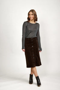 Woman wearing a charcoal long sleeve top and dark brown corduroy button-front midi skirt