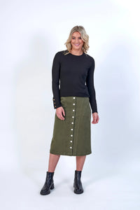 Woman wearing a khaki button-front midi skirt, black top, and black ankle boots.
