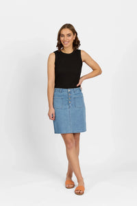 Woman in a sleeveless black top and light blue denim skirt with front buttons and pockets.