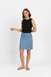 Woman wearing a denim button-front skirt, black sleeveless top, and orange sandals