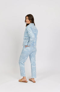 Woman modeling light blue denim jacket and jeans with white heart pattern, casual fashion.