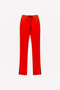 Bright orange women's pants with black drawstring and side stripe, front view on white background