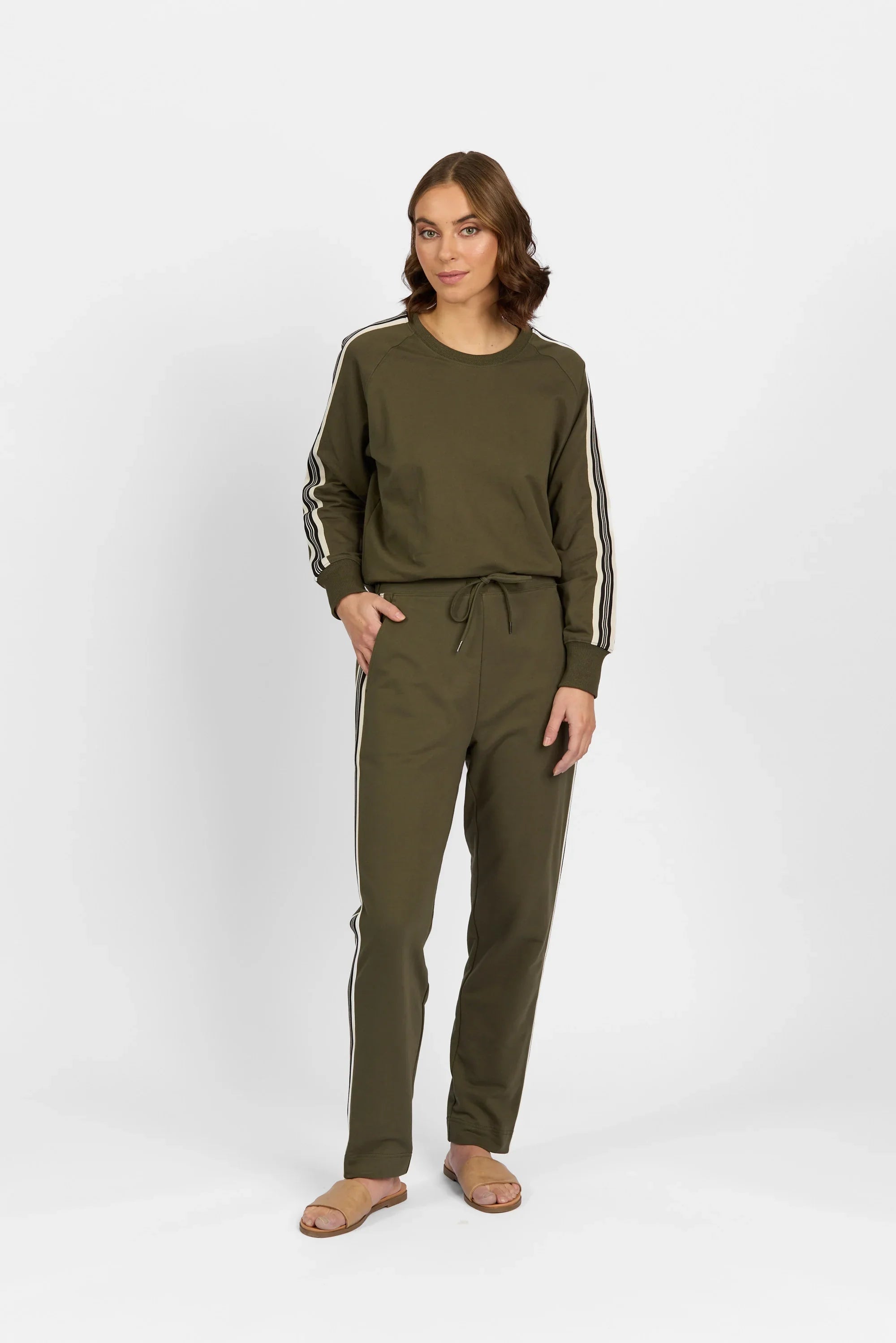 Woman wearing olive green lounge set with striped long sleeves and pants, casual look