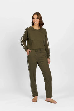 Woman wearing khaki pants and matching long-sleeve top with side stripes on white background
