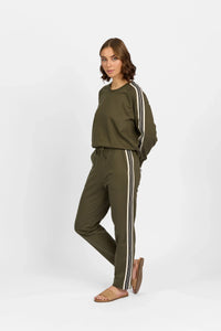 Woman wearing khaki pants and top with white stripes, casual fashion outfit