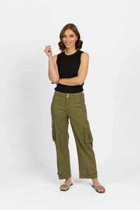 Woman wearing khaki cargo pants and a black sleeveless top, posing against a white background.