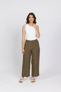 Woman in wide-leg khaki pants with belt, white sleeveless top, and white sandals