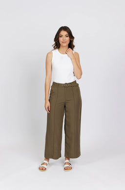 Woman in wide-leg khaki pants with belt, white sleeveless top, and white sandals