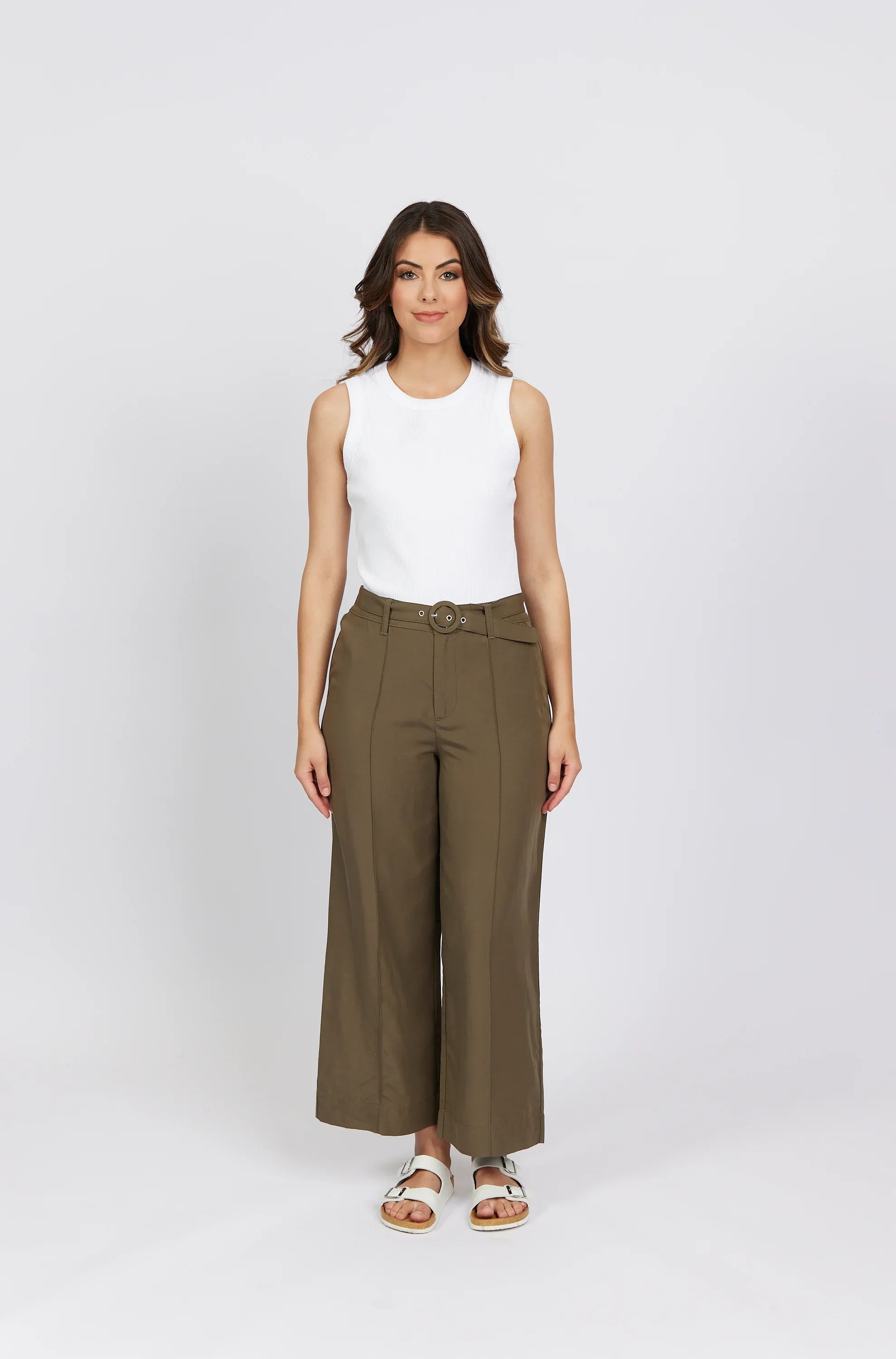 Woman wearing khaki wide-leg high-waist pants with belt and a sleeveless white top