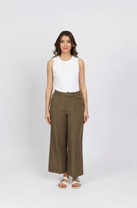 Woman wearing khaki wide-leg high-waist pants with belt and a sleeveless white top