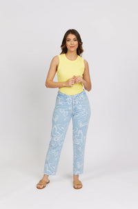 Woman wearing light blue heart print jeans, yellow sleeveless top, and tan sandals