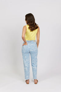 Woman in yellow tank top and light blue jeans with white heart print, back view