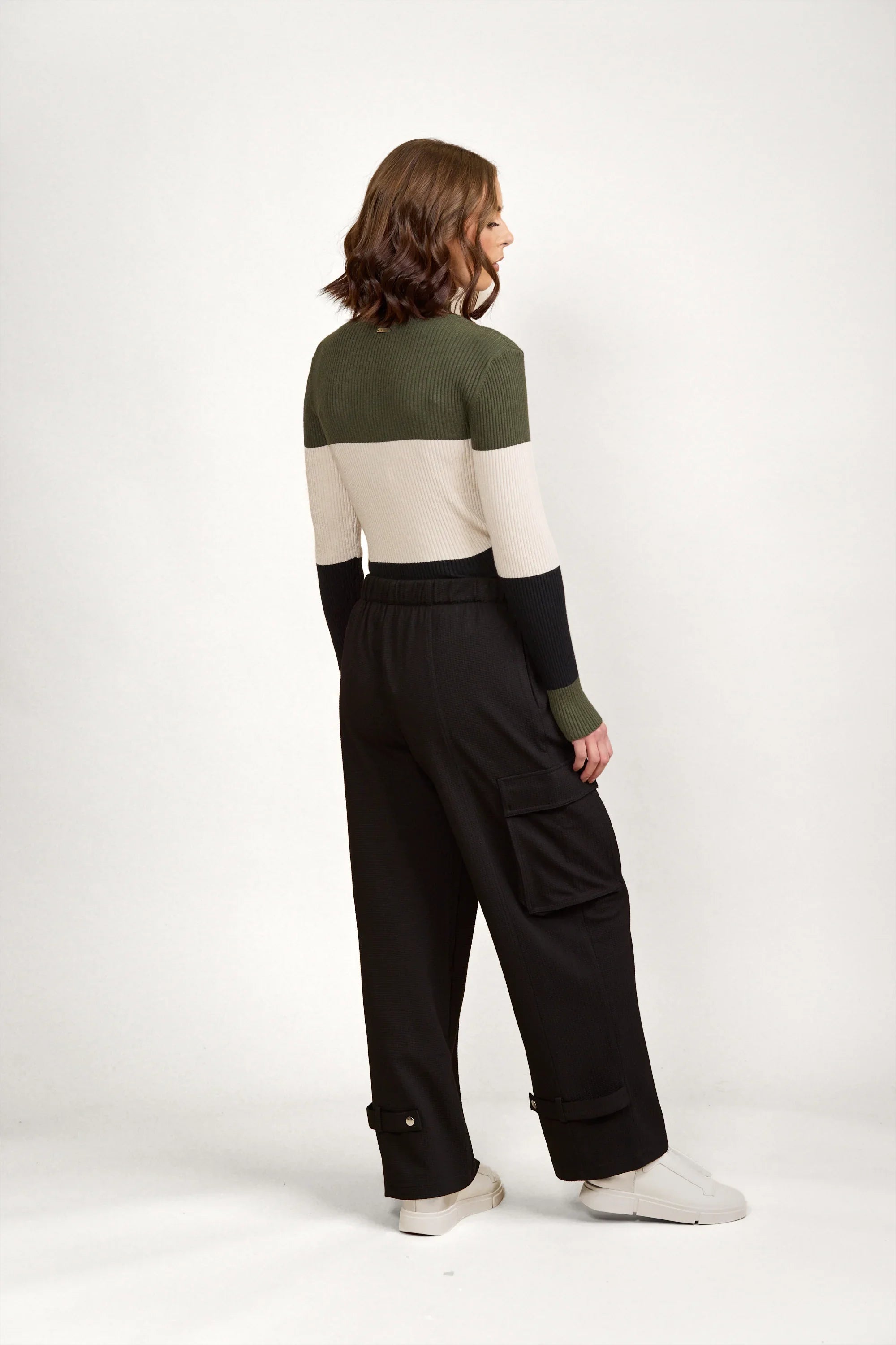 Woman wearing black cargo pants with side pockets and cuff details, casual style