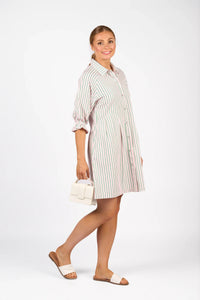Woman in a striped button-up shirt dress with puff sleeves, holding a white handbag