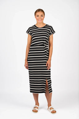 Woman wearing a black and white striped midi dress with short sleeves and front slit