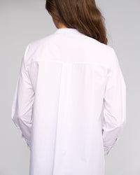 A person with long brown hair is shown from the back wearing the Vassalli Manhattan Shirt in white, set against a light gray background.