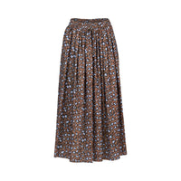 The Maxi Skirt - Nala by Vassalli is a brown printed cotton skirt with a light blue and black abstract spotted pattern, featuring a gathered elastic waistband and a loose, flowy silhouette.